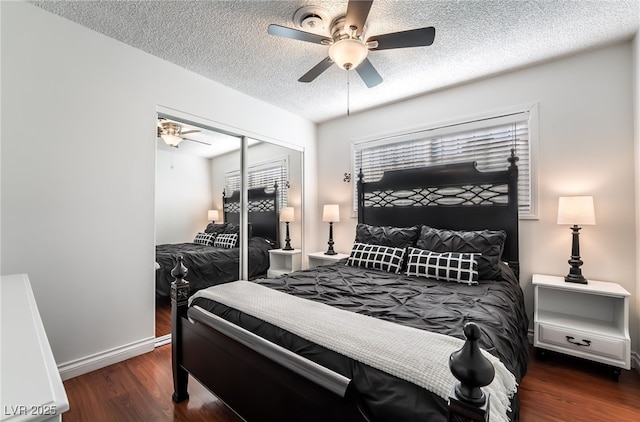 bedroom featuring a textured ceiling, dark wood-style flooring, a ceiling fan, baseboards, and a closet