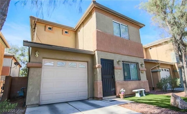 townhome / multi-family property featuring an attached garage, concrete driveway, and stucco siding