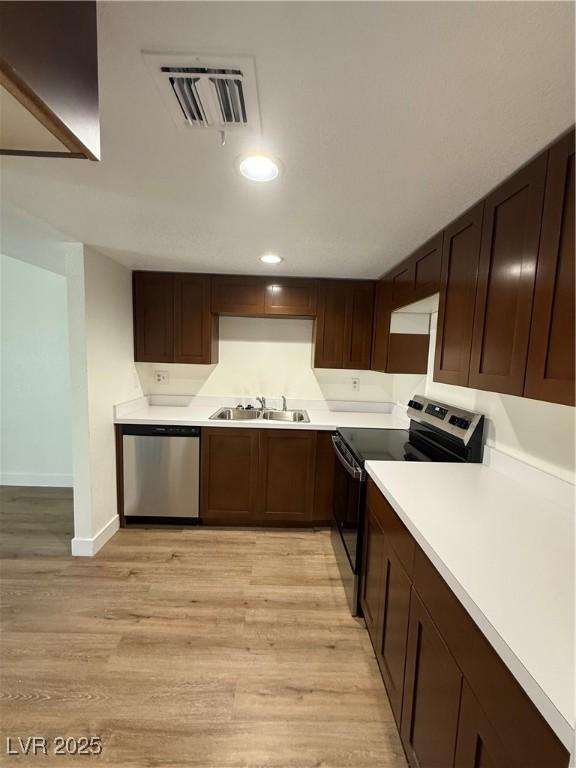 kitchen with electric stove, light countertops, visible vents, a sink, and dishwasher