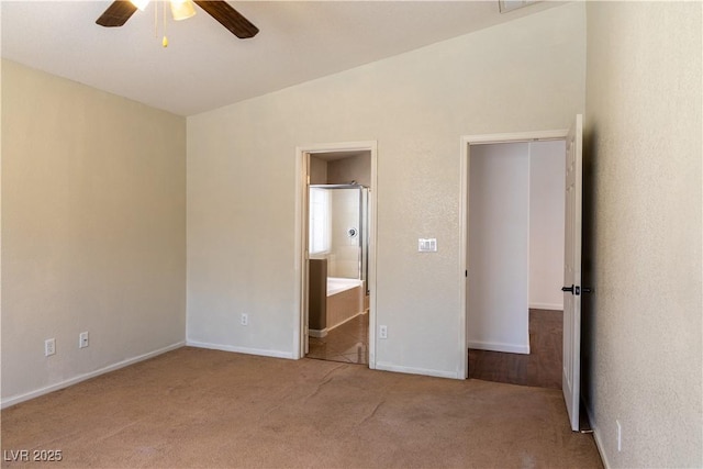 unfurnished bedroom with ensuite bath, baseboards, ceiling fan, and carpet flooring