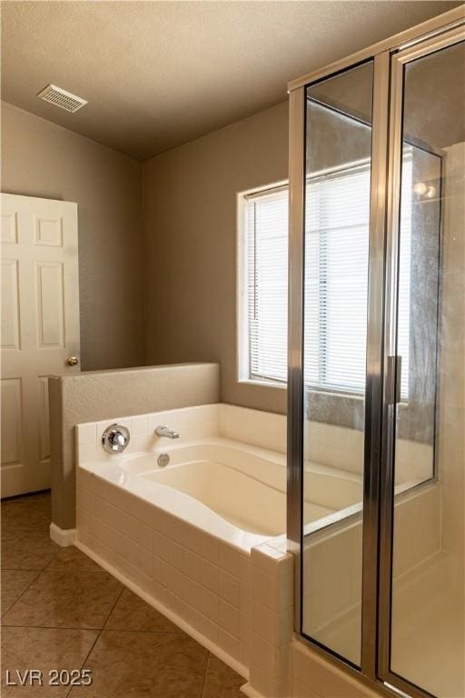 bathroom with a stall shower, tile patterned flooring, visible vents, and a bath