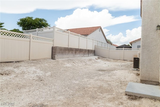 view of yard featuring a fenced backyard and central AC