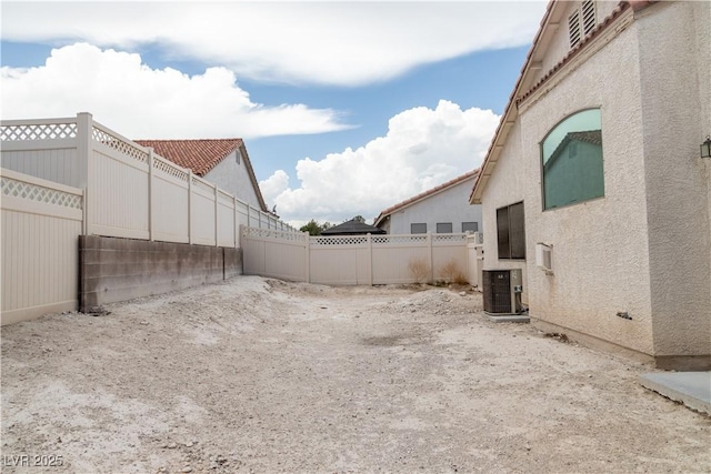 view of yard featuring fence and central air condition unit