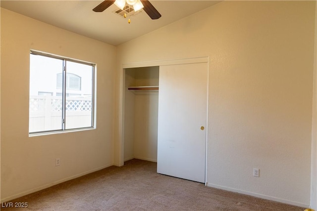 unfurnished bedroom featuring vaulted ceiling, a closet, a ceiling fan, and light colored carpet