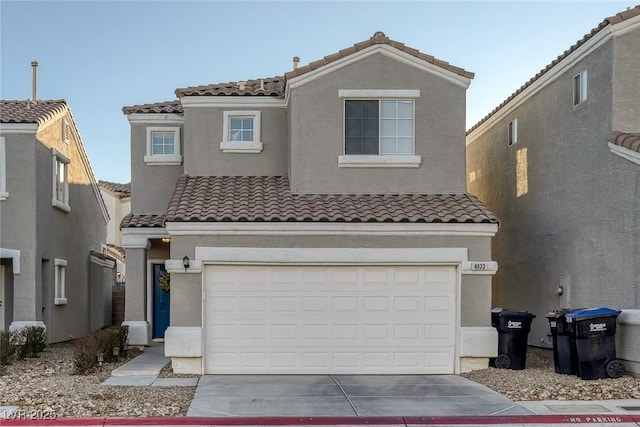 view of front of property with a garage, a tiled roof, concrete driveway, and stucco siding