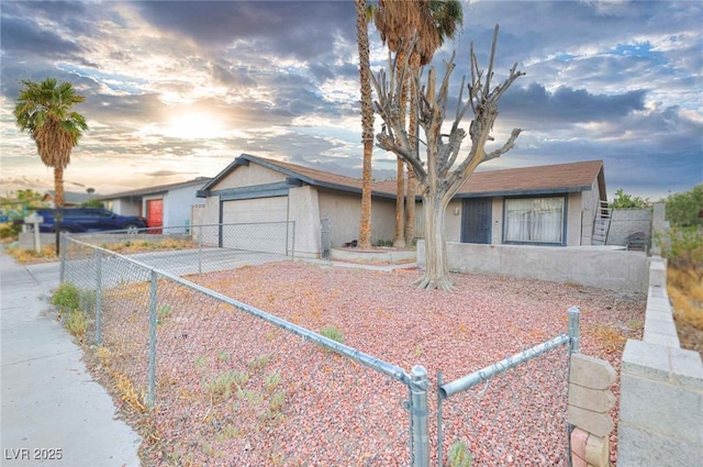 view of front of house with a fenced front yard, concrete driveway, an attached garage, and stucco siding