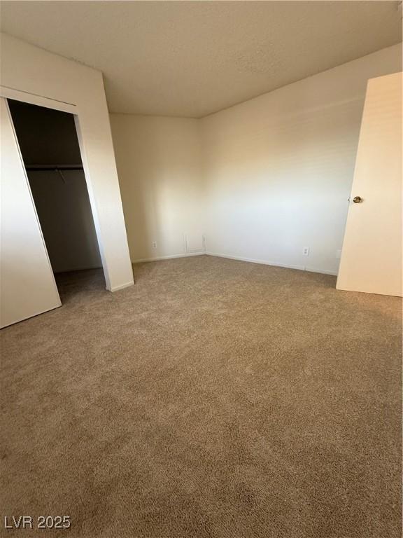 unfurnished bedroom featuring carpet, a textured ceiling, and a closet