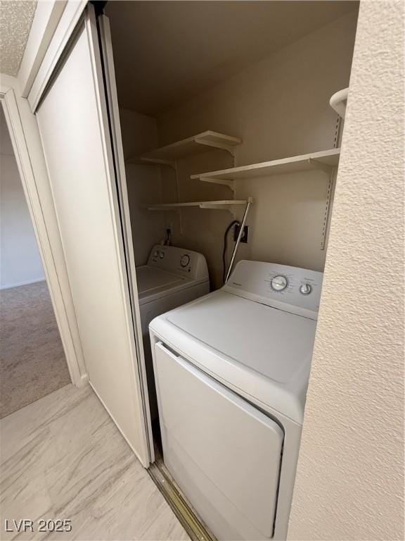 laundry room with washer and dryer, laundry area, and a textured ceiling