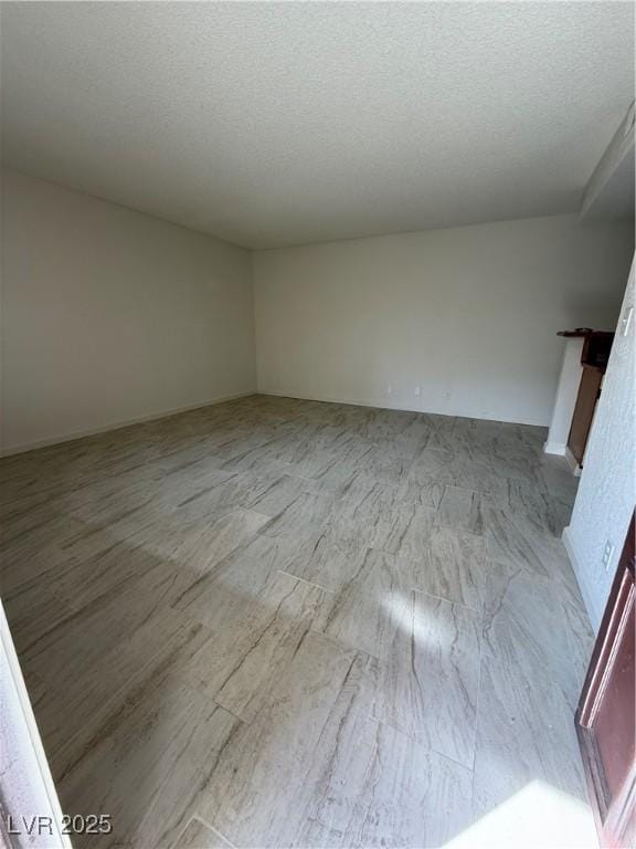 spare room with light wood-style flooring and a textured ceiling