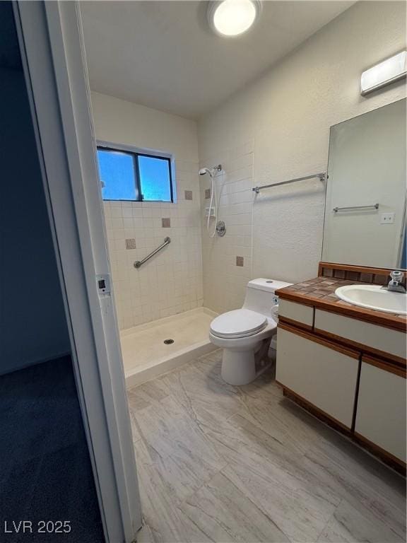 full bath featuring a stall shower, vanity, and toilet