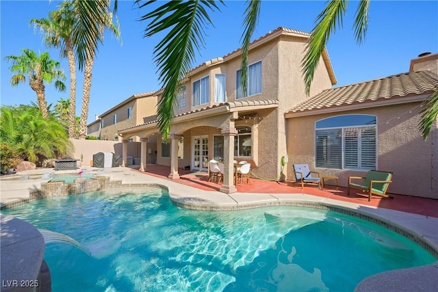 rear view of house with a patio, fence, a tiled roof, and stucco siding