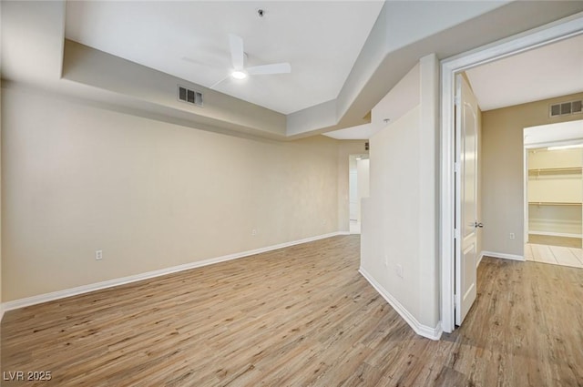 unfurnished room featuring visible vents, ceiling fan, light wood-style flooring, and baseboards