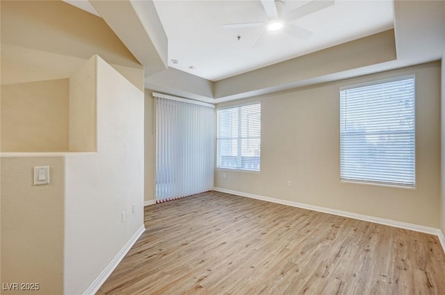 unfurnished room with a ceiling fan, baseboards, and light wood finished floors