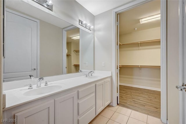 full bath with double vanity, a sink, and tile patterned floors