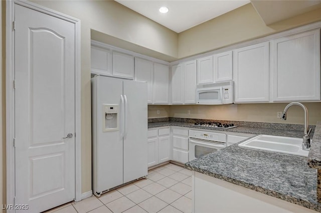 kitchen featuring light tile patterned floors, recessed lighting, white cabinetry, a sink, and white appliances