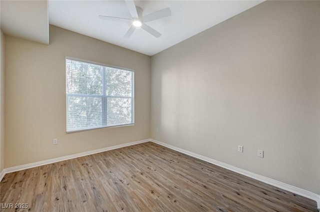 empty room featuring ceiling fan, baseboards, and wood finished floors