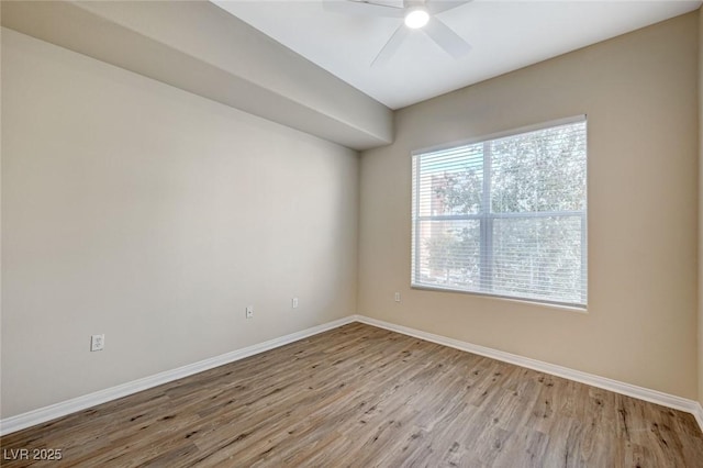 empty room featuring light wood-style floors, baseboards, and a ceiling fan