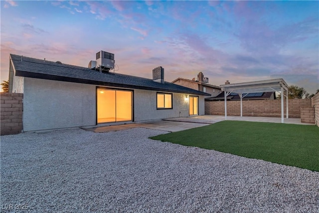 rear view of property featuring cooling unit, a fenced backyard, stucco siding, and a patio area