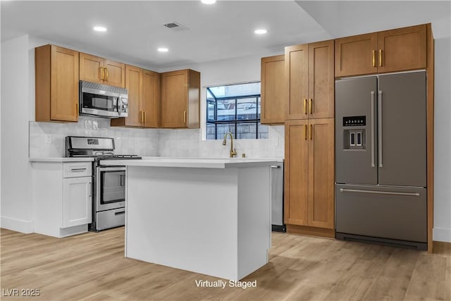 kitchen with visible vents, light wood-style floors, appliances with stainless steel finishes, and light countertops