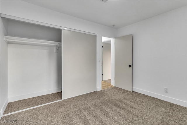 unfurnished bedroom featuring carpet, a closet, and baseboards