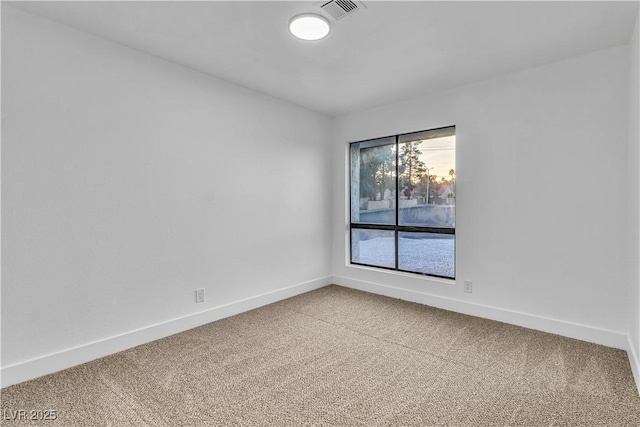 empty room featuring carpet flooring, baseboards, and visible vents