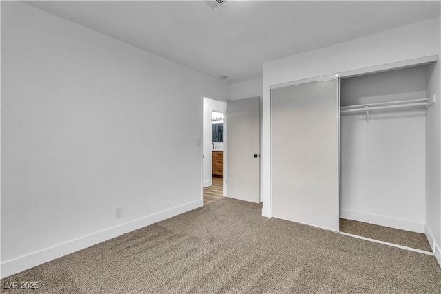 unfurnished bedroom featuring visible vents, carpet, a closet, and baseboards