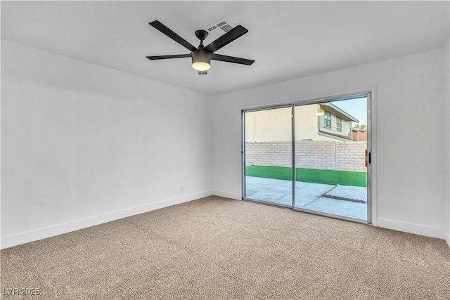 carpeted spare room featuring visible vents, baseboards, and a ceiling fan