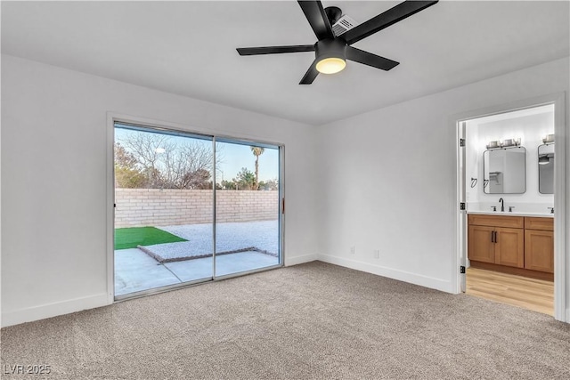 unfurnished bedroom with a sink, baseboards, light colored carpet, and access to exterior