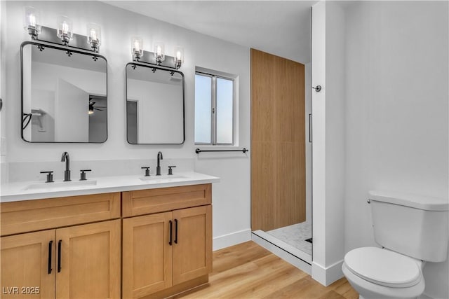 full bath featuring walk in shower, a sink, toilet, and wood finished floors