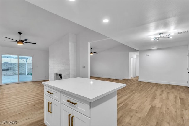 kitchen featuring open floor plan, a ceiling fan, light wood-style floors, and visible vents