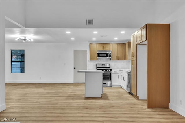 kitchen featuring light wood-type flooring, visible vents, backsplash, open floor plan, and stainless steel appliances