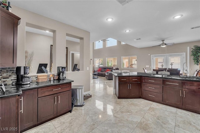 kitchen featuring a sink, decorative backsplash, visible vents, and ceiling fan