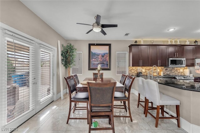 dining room with visible vents, a ceiling fan, and baseboards