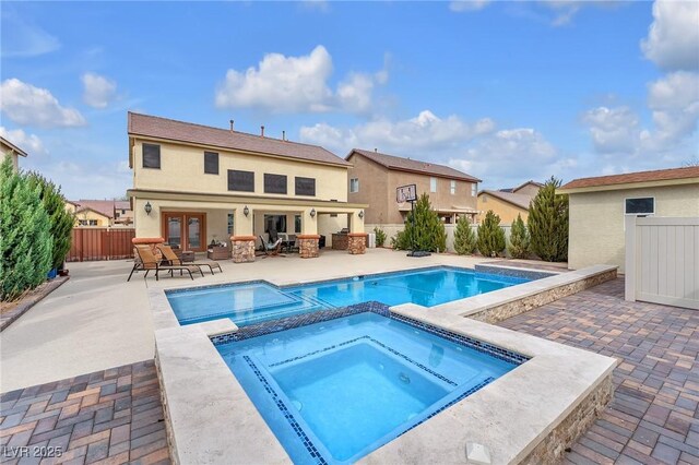 view of pool featuring a patio area, a fenced backyard, and a pool with connected hot tub