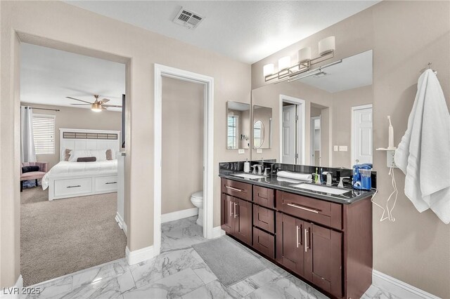 ensuite bathroom with visible vents, marble finish floor, ceiling fan, and a sink