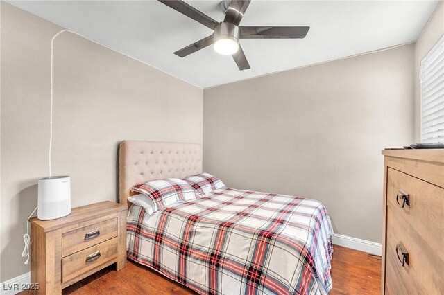 bedroom with a ceiling fan, baseboards, and wood finished floors