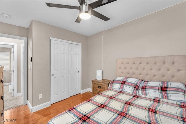 bedroom featuring a closet, baseboards, light wood-style flooring, and a ceiling fan