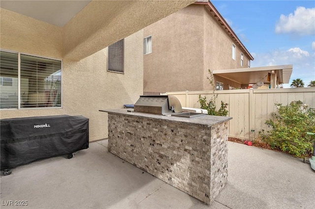 view of patio / terrace with area for grilling and fence