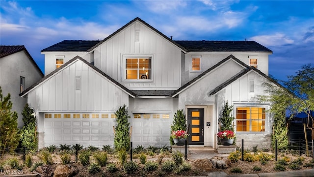 modern inspired farmhouse featuring board and batten siding and a garage