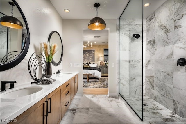 bathroom featuring double vanity, ensuite bathroom, marble finish floor, a walk in shower, and a sink