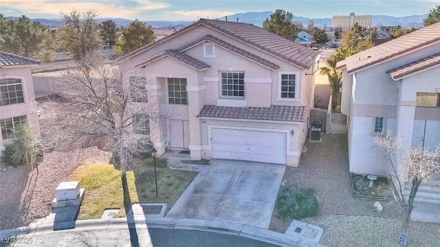 view of front of house featuring driveway, a tiled roof, an attached garage, central air condition unit, and stucco siding