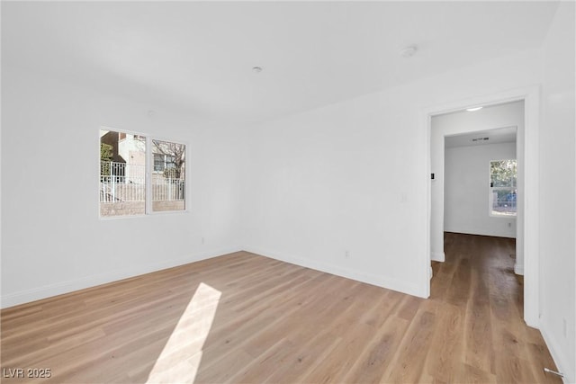 empty room with light wood finished floors and baseboards