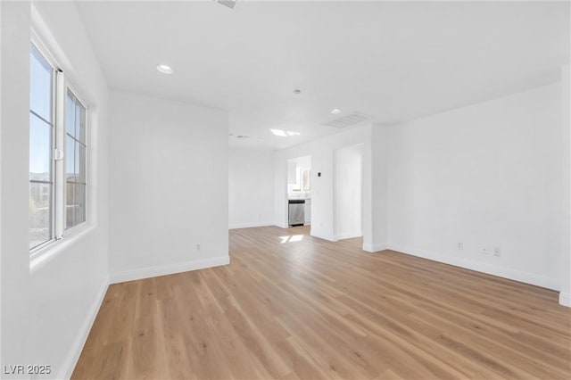 unfurnished living room featuring recessed lighting, light wood-style flooring, and baseboards