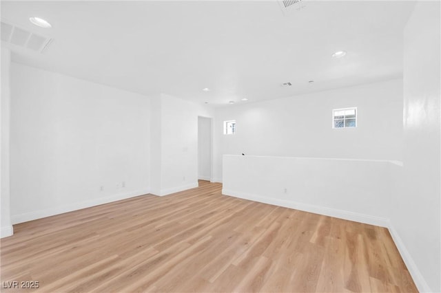 spare room with light wood-style floors, baseboards, visible vents, and recessed lighting