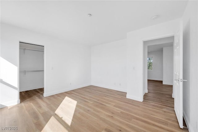 unfurnished bedroom featuring a closet, light wood-style flooring, and baseboards