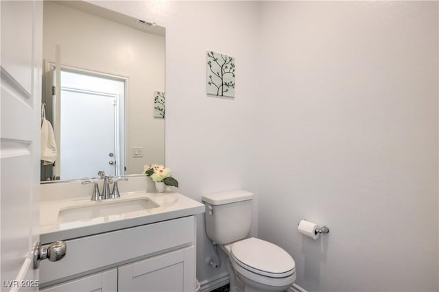 half bath with toilet, visible vents, and vanity