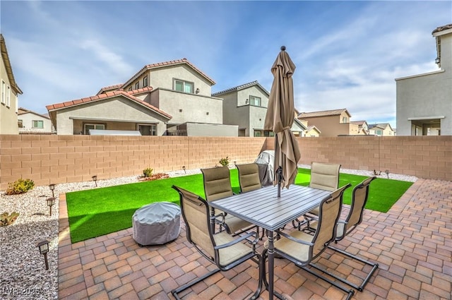 view of patio / terrace featuring outdoor dining area, a fenced backyard, and a residential view