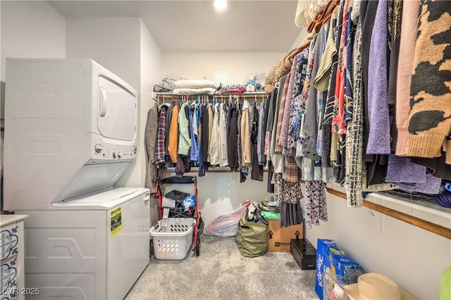 spacious closet with carpet floors and stacked washer / drying machine