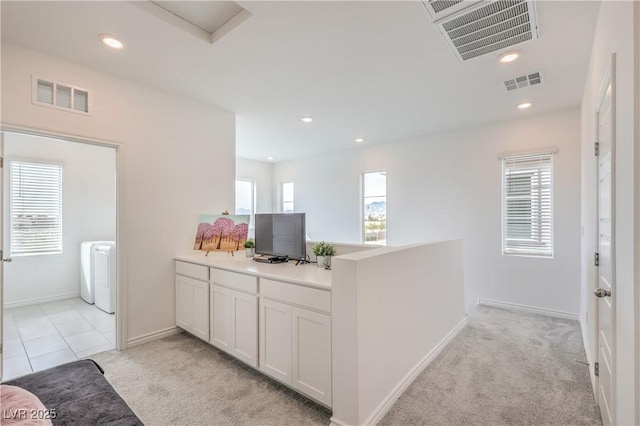 kitchen featuring light colored carpet, light countertops, visible vents, and white cabinetry