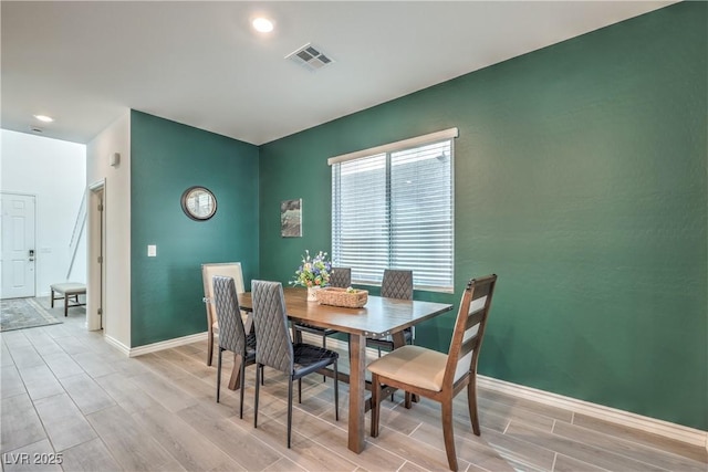 dining room with wood finish floors, visible vents, and baseboards